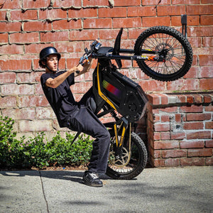 Freego Nova 4 electric bike wheelie action shot against brick wall