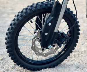Close-up of Freego X0 electric bike’s front wheel with knobby off-road tire, disc brake, and suspension fork.