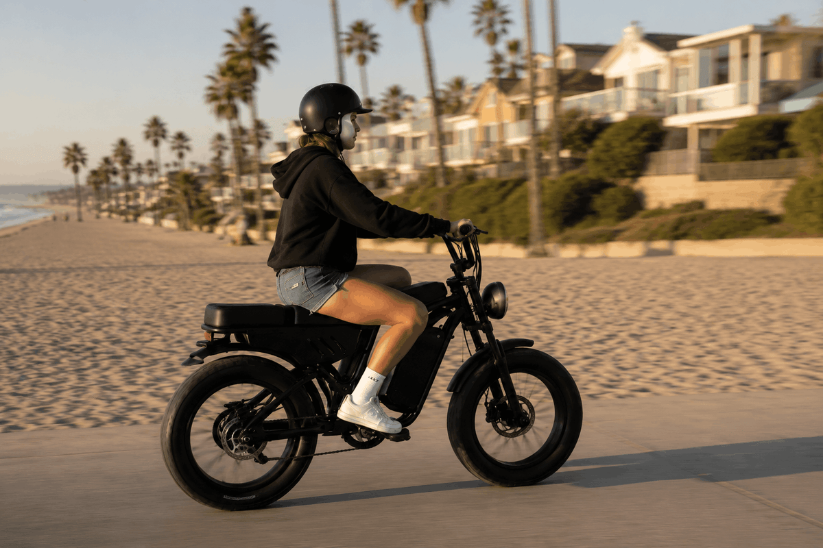 Girl riding Freego F0 fat tire electric bike along a beach road