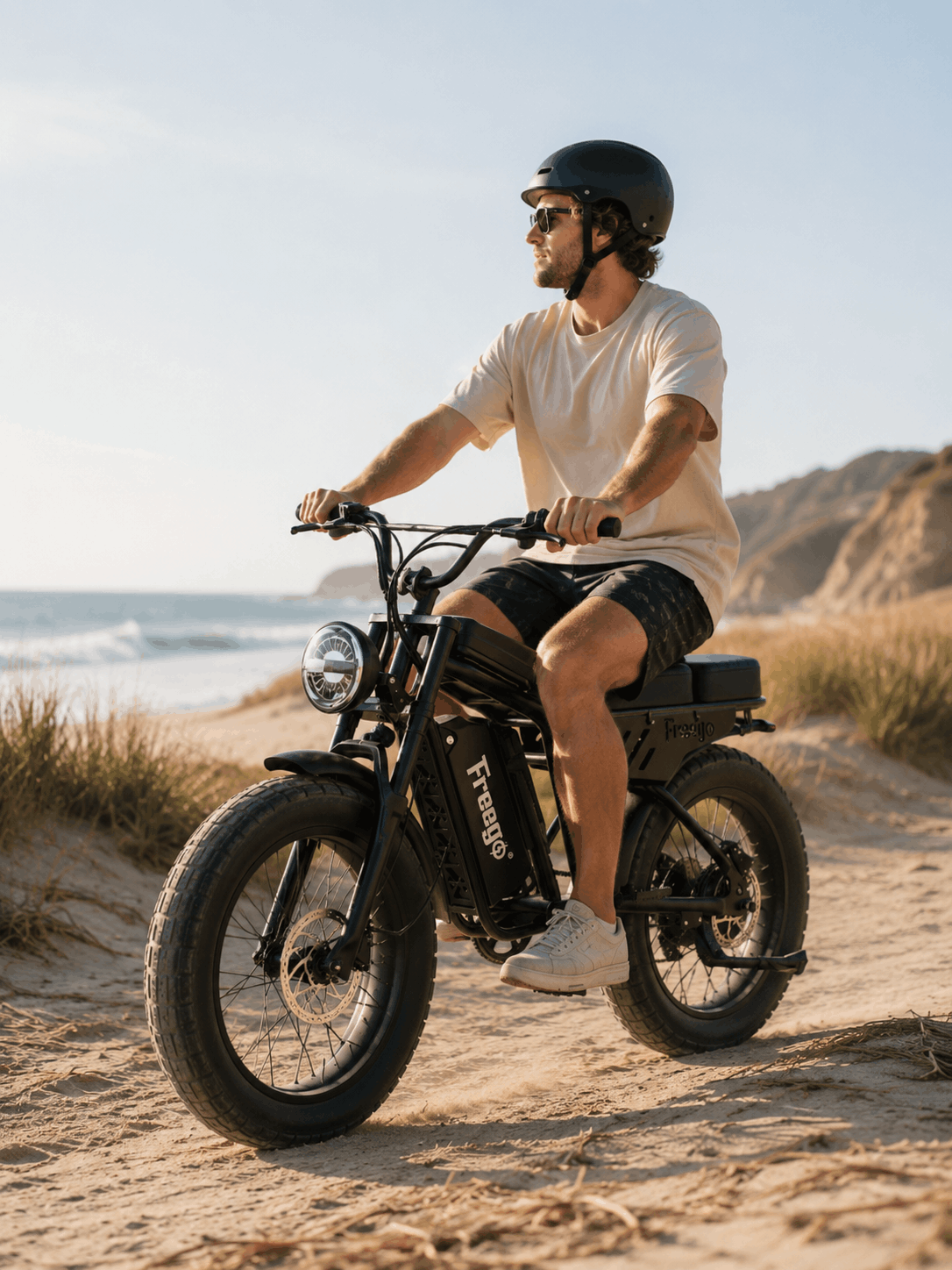 Freego F0 fat tire electric bike riding on a sandy beach road near the ocean