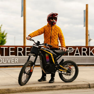 Freego Nova 4 electric dirt bike with rider holding bike on city path