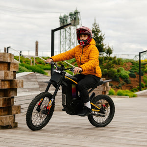 Freego Nova 4 electric dirt bike rider on wooden boardwalk in outdoor park