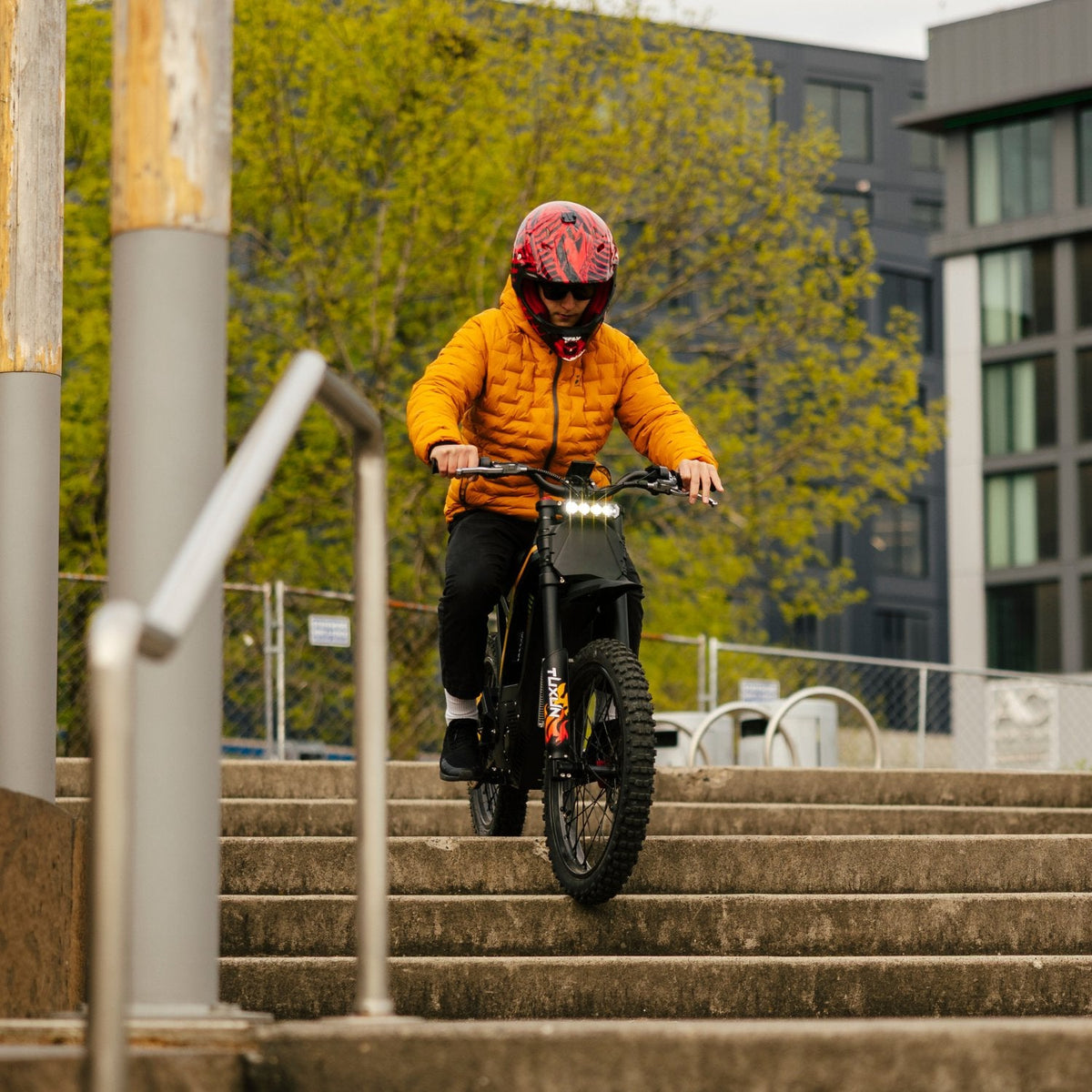 Freego Nova 4 electric dirt bike riding down steps action in urban park