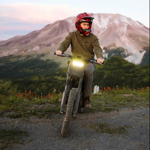 Rider wearing a helmet on a Freego Nova 4 against a mountain backdrop, showcasing high-performance off-road adventure riding.