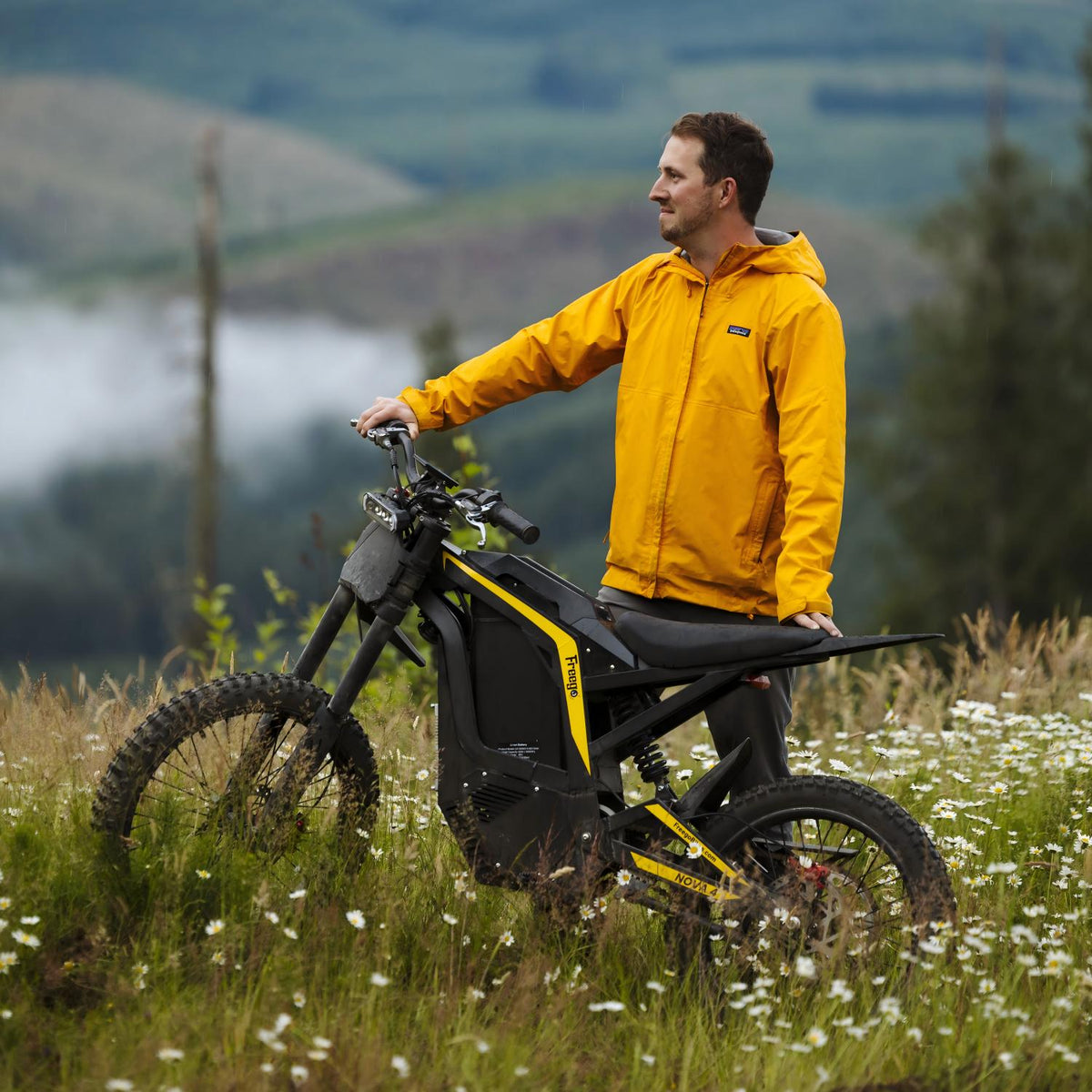 Rider standing beside a Freego Nova 4 in a mountain meadow, showcasing rugged off-road performance and outdoor adventure.