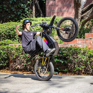 Freego Nova 4 electric bike wheelie action shot with rider gesture