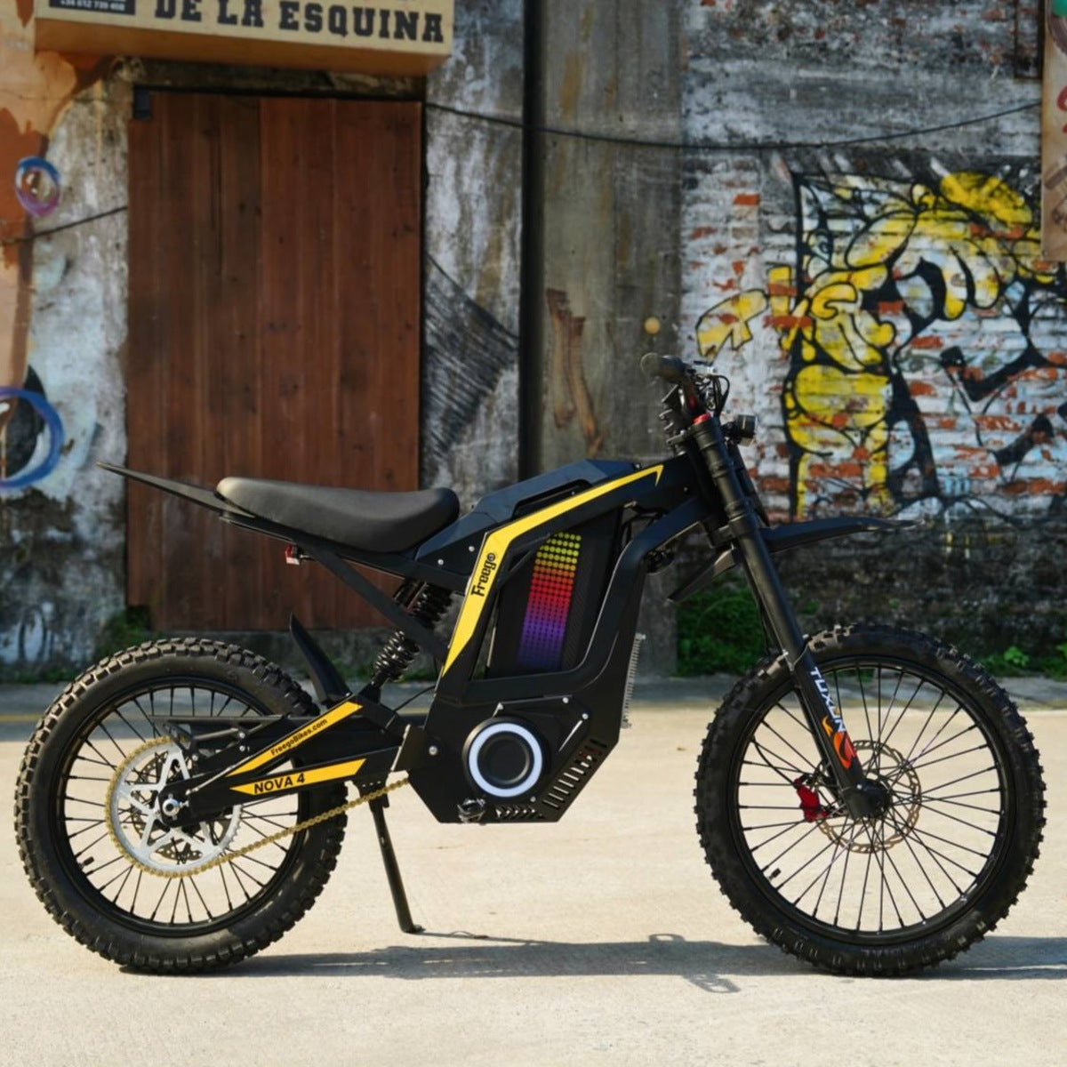Freego Nova4 electric dirt bike left side view parked in front of graffiti wall